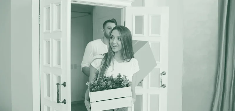 Paar trägt Umzugskisten in eine neue Wohnung